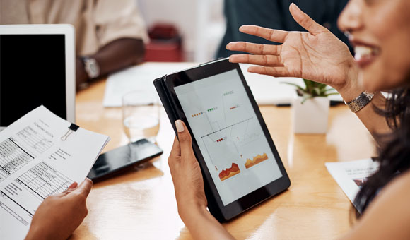 Woman explaining the graphics displayed on a tablet